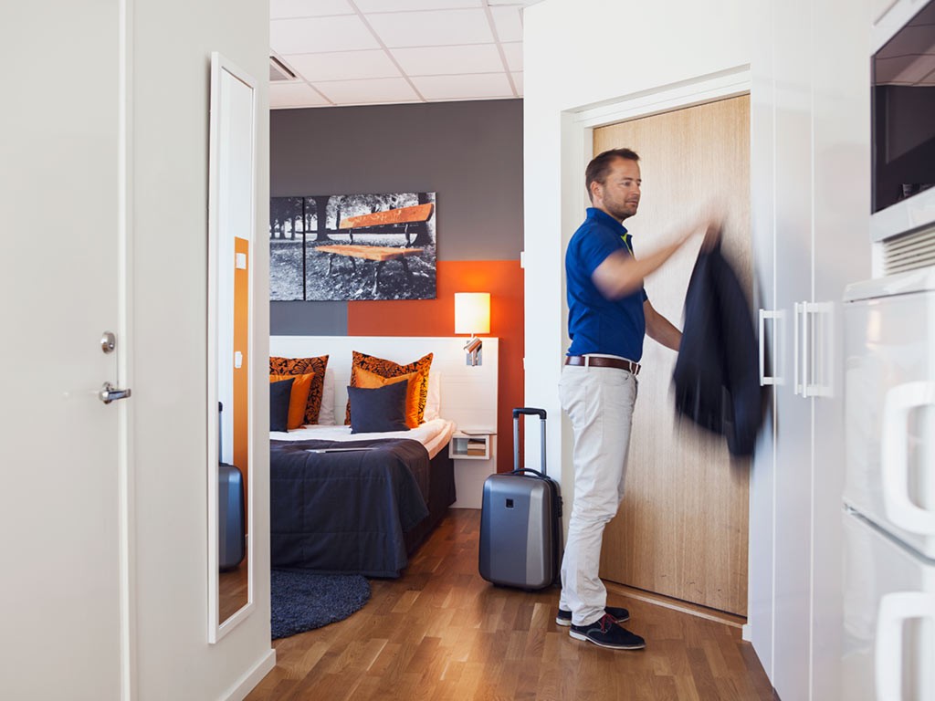 Guest hangs up clothes in hotel room in Linköping Tornet