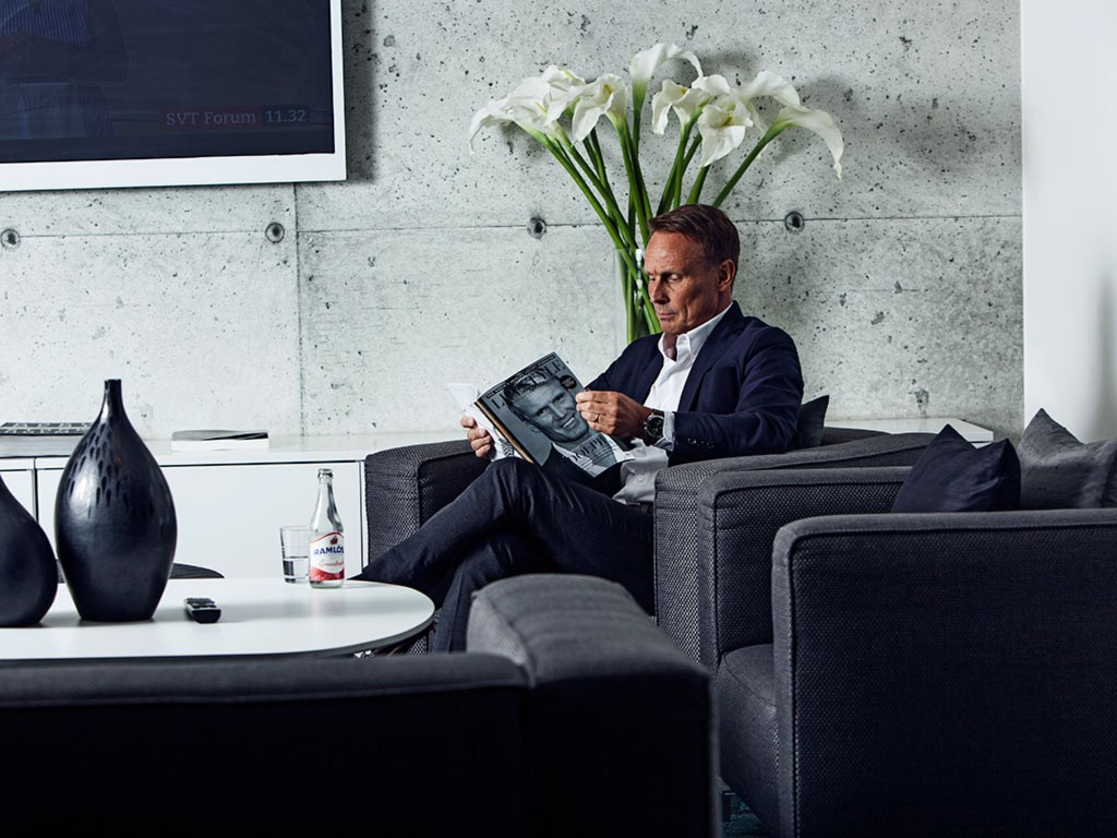 Person läser tidning i Lounge Sky Hotel Apartments Stockholm