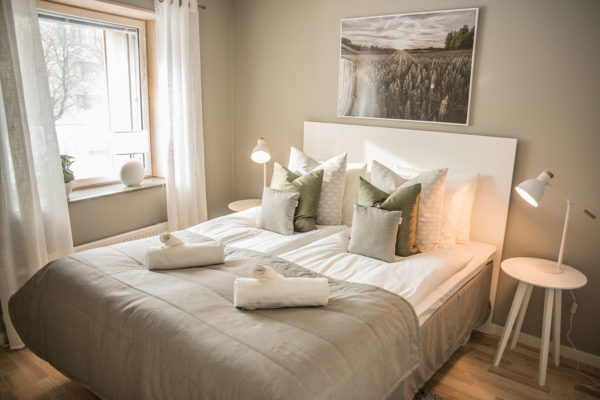 Double bed by window in bedroom hotel room in Valla Berså small 2 bdrm apt